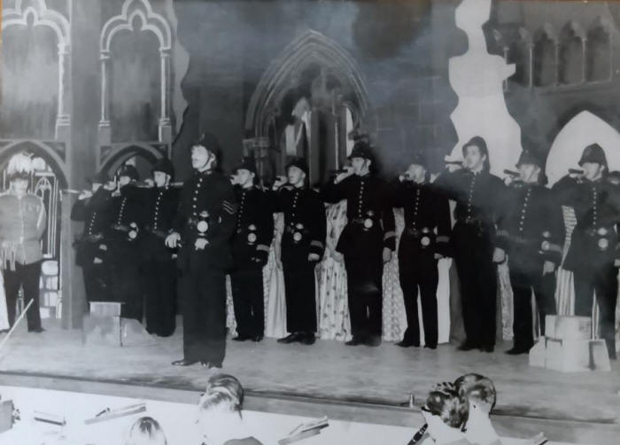 A picture containing text, old, group, posing